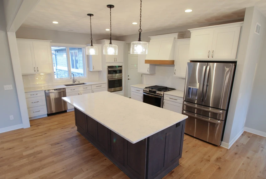 Renovated kitchen with white cabinets and wood floors