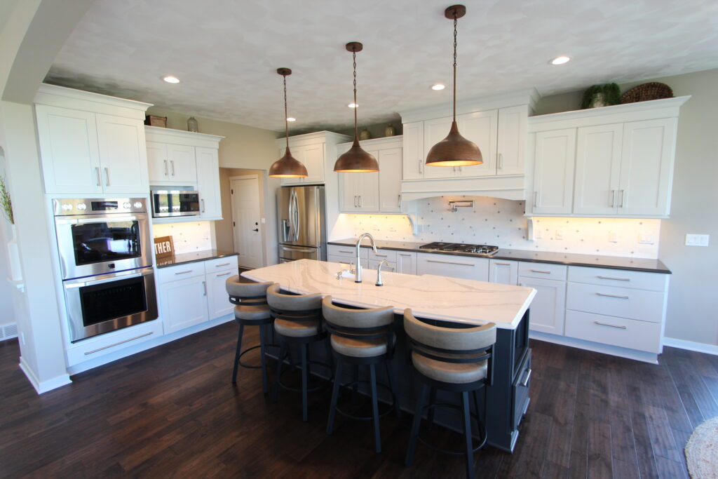 Renovated kitchen with white cabinets and wood floors